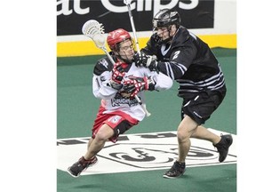 Calgary Roughnecks star Shawn Evans, left, and the Edmonton Rush’s Brett Mydske battle during their NLL west final playoff game at the Scotiabank Saddledome.