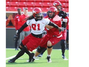 Calgary Stampeders defensive lineman Kevin Dixon fights for position with offensive lineman Brad Erdos during practice on Thursday.