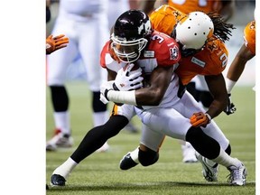 Calgary Stampeders’ Jeff Fuller, left, is tackled by B.C. Lions’ Lin-J Shell during a game last November. Shell is now a member of the Stampeders.
