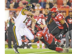 Calgary Stampeders linebacker Juwan Simpson tried to stop a hard-charging Dan LeFevour of Hamilton during Friday’s game.
