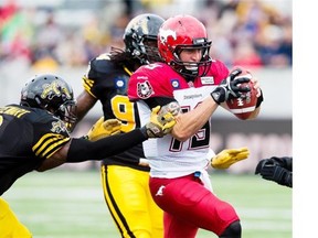 Calgary Stampeders’ quarterback Bo Levi Mitchell, right, hands the ball off to Martell Mallett, during first quarter CFL football action against the B.C. Lions in Calgary, Alta., Friday, Aug. 1, 2014.