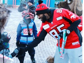 Calgary Stampeders wide receiver Joe West, seen handing out medals to some of the 1000 runners who braved North Pole like temperatures to raise money for the Salvation Army in the organization’s annual Santa Shuffle run last December, has been ailing, but is nearing a return to the club’s training camp football activities.