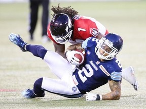 Chad Owens of the Toronto Argonauts is brought down by Lin-J Shell of the Calgary Stampeders during a game last Saturday in Toronto.
