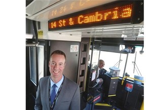 Chris Jordan, Acting Calgary Transit Director, and driver Shafiq Rawji show off the new signage implementing Calgary Transit’s new real-time bus information.