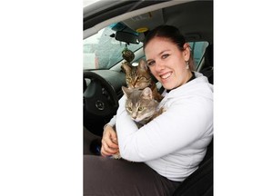 Christine Campbell with Oops-A-Dazy animal rescue and sanctuary, shown with her own two cats, says she is pleased the 42 dogs seized from the organization’s foster home have been returned by the Alberta SPCA, but “heartbroken” that 20 seized cats had been euthanized.