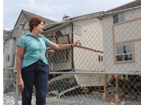 Colleen Vukadinovic looks at her home in Canmore that was severely flooded by Cougar Creek and is now being torn down.