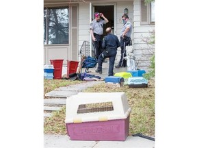 Crews entering the house where over 40 dogs were found abandoned, wear full breathing apparatuses due to hazardous conditions created by animal decal matter in Calgary, on May 13, 2014. Between 40 and 50 dogs were found in this home on Addison Drive SE.