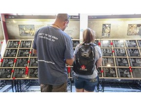 Crystal Gellner, right, and Frank Gaebel, both of Regina, reflect at the commemorative Afghanistan Memorial Vigil which is making a three-day stop at the Calgary Tower main floor. The vigil is made up of plaques that were once part of the Kandahar Airfield cenotaph.