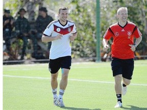 Darcy Norman, right, is seen during training of Germany’s World Cup soccer team next to team forward Lukas Podolski, left, in this provided photo.