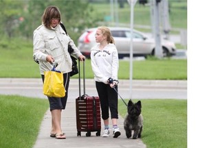 Discovery Ridge residents Diane Sands and her daughter Mary, 11, walked with their dog Stewie back to their home after being evacuated on Thursday after the Elbow River spilled over the banks and flooded a large area surrounding it.