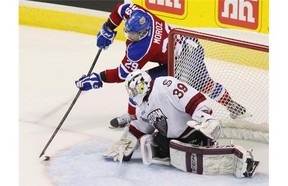 Edmonton Oil Kings Mitchell Moroz of Calgary tries a wrap-around shot on Guelph Storm goalie Justin Nichols during their round-robin meeting at the Memorial Cup. Edmonton later beat Guelph in the final.