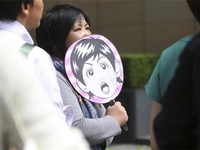 A fan of Paul McCartney waits outside of a hotel believed to be stayed by McCartney in Tokyo, Tuesday, May 20, 2014. The former Beatle is canceling his entire Japan tour because of illness including the one set for Wednesday at Nippon Budokan hall, where The Beatles performed during their first Japan tour in 1966. (AP Photo/Eugene Hoshiko)