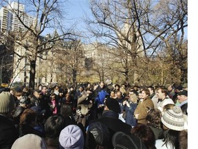 Fans gather and sing on the 25th anniversary of the late Beatle John Lennon’s death at the Imagine memorial to Lennon in the Strawberry Fields section of New York’s Central Park. The Dakota apartment building where Lennon lived and where he was shot and killed, is in the background.