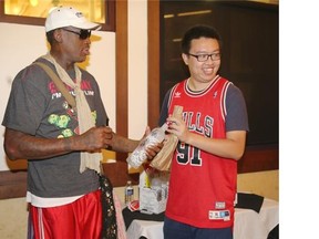 Former basketball star, and five-time NBA champion, Dennis Rodman signs a bottle of his new vodka for Gu Chen as he made a brief appearance in Calgary at Co-op Wine and Spirits located at 39 Crowfoot Way N.W.  late Saturday afternoon to promote his new vodka. It is estimated around 400 people lined up to purchase and have the celebrity sign bottles of his "Bad Ass" brand vodka. Co-op brought in some 240 cases for the event.