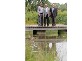 From left, Barry Bishop, head of conservation programs, Ducks Unlimited Canada; Robin Campbell, Minister of Environment and Sustainable Resources Development; and Jeff Surtees, CEO, Trout Unlimited Canada, pose for a picture following an announcement of new programs focusing on healthy watersheds and fish habitats, at Bow Habitat Station in Calgary on Wednesday.