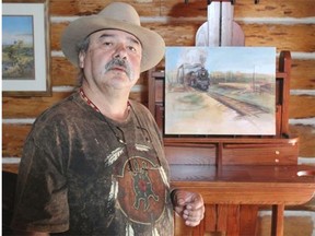 High River artist Rocky Barstad, with one of his paintings of the former train bridge with a steam engine going over the Highwood River, is trying to put his life back together after last June’s flood.