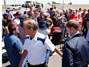 High River mayor Emile Blokland and MLA Rick Fraser retreat from a group of frustrated evacuated High River residents following a press conference about the timeline for them to re-enter the town of High River, Alberta on June 26, 2013. An announcement that any return by residents of flood-stricken High River, Alberta is still days away further incited an angry crowd gathered just 100 metres away outside a police perimeter. THE CANADIAN PRESS/Jordan Verlage