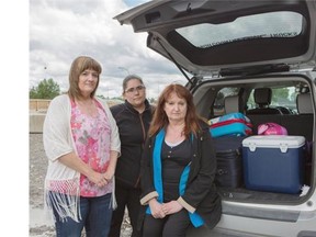 Holly Palacsko, left, Kathleen Hayes, centre, and, Wanda Melsness, right, have their suitcases packed and ready to go in case they need to flee Wallaceville. (Jenn Pierce/Calgary Herald)