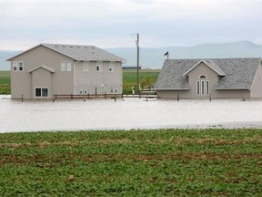 A home is surrounded by water outside of Claresholm on June 19.
