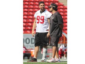 Injured Calgary Stampeders defensive lineman Corey Mace wears a brace at practice while chatting with Special Teams Co-ordinator Mark Kilam on Wednesday.