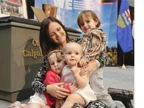 Jacquelyn Mitchell with her three children Halle, 3, Hunter 3, and Hana, who was born on June 21, 2013, during the floods, attend the one-year anniversary ceremony at City Hall on Friday.