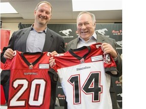 Jamie Crysdale, left, and Ron Allbright hold jerseys presented to them and others inducted to the Stampeders’ 2014 Wall of Fame class on Monday.