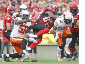 Joe West of the Calgary Stampeders tries to break through the defence of the BC Lions at McMahon Stadium.