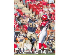 Bo Levi Mitchell of the Calgary Stampeders gets a pass off before Louie Richardson of the Winnipeg Blue Bombers closes in on him during the first half at McMahon Stadium on Saturday.