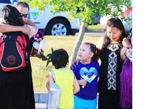 Jimmy Crowshoe, far left, the father of Colton Crowshoe, is hugged as he arrives at a vigil for his son Colton Crowshoe at the Abbydale Community Centre field on July 27. Colton’s family wants police to undergo First Nations-specific diversity training over their concerns with the investigation into the missing 18-year-old.