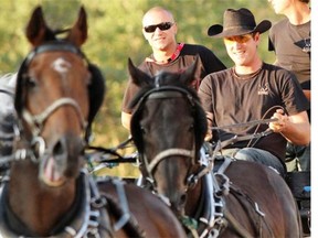 Jordie Fike, right, seen with UFC fighter Mark Hominick during a 2012 Calgary Stampede training run, was in good shape to make the 2014 Rangeland Derby semifinals until he tipped a barrel on Thursday night.