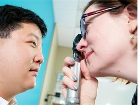 Jung-Suk Ryu has his eyes checked by optometrist Colleen Gnyp during a free clinic at the Calgary Centre for Newcomers on Monday.