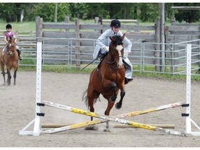 Katelyn Lackie takes a jump on Kodi at a sidesaddle clinic held at the Bar U Ranch.