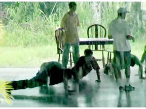 Kids do pushups in the rain in the documentary, Kidnapped for Christ. 
 Courtesy, Kate Logan.