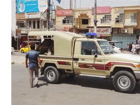 Kurdish security forces deploy in the oil-rich city of Kirkuk, 290 kilometres north of Baghdad on Friday. Iraqi officials say al-Qaida-inspired militants who this week seized much of the country’s Sunni heartland have pushed into an ethnically mixed province northeast of Baghdad, capturing two towns there. The writing on the metal shutters at left advertises a shop for sale.