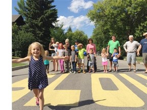 A large yellow ‘Slow’ sign painted on 14A Street S.W. briefly helped ease the problem of speeding drivers, a residents says, that is until the city washed away the “illegal” traffic enforcement message.