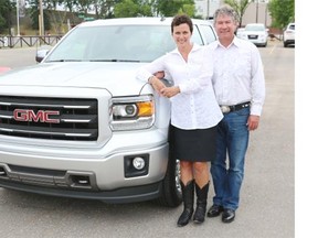Laura MacMillan, with her fiance Perry Kopec, stands with her new GMC Truck that she won as part of the Kinsmen GMC Truck and Toys Package in the Calgary Stampede Lotteries, in Calgary on Wednesday