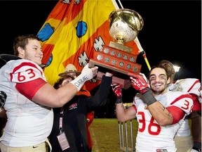 Laval Rouge et Or Pierre Lavertu, left, and Vincent Plante hold the Uteck Bowl after defeating the Mount Allison Mounties 48-21 in university football action at MacAulay Field in Sackville, N.B. on Saturday, Nov. 16, 2013.