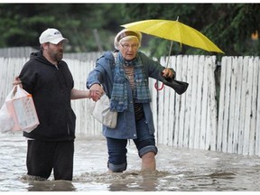 Anna DiPalma, 76, gets a helping hand from Kris Iversen as they make their way along Bowness Road in Calgary.