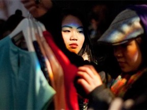 A customer peers around a changing room door as she tries on an outfit designed by Jason Wu at a Target pop-up shop in Toronto on Thursday February 23, 2012. While pop-ups can be used for a variety of reasons, its primary purpose has been promotional, said Ken Wong, faculty member in the school of business at Queen's University. He pointed to U.S. discount retailer Target which operated a pop-up north of the border ahead of its Canadian launch last year, a move he said was "extremely successful" in generating buzz. THE CANADIAN PRESS/Chris Young.