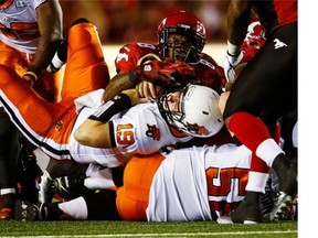 B.C. Lions quarterback Travis Partridge, centre, gets a first down on a quarterback sneak during second half CFL football action against the Calgary Stampeders in Calgary, Alta., Friday, Aug. 1, 2014. THE CANADIAN PRESS/Jeff McIntosh