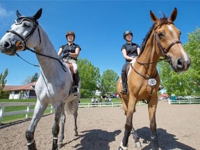 Local equestrian competitors and sisters, Bretton, left, and Kara Chad, ride at Spruce Meadows on Tuesday.