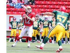 Local quarterback Brett Hunchak, left, looks for an open receiver at the Annual high school football provincial all-star game, the Senior Bowl, at McMahon Stadium on May 20, 2013.