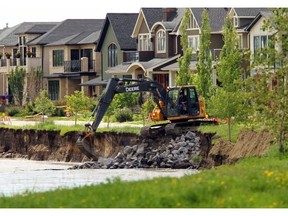FILE - Emergency crews try to build a berm to protect some homes on 8th Ave. S.E. in Inglewood on June 23, 2013. The province announced $325 million in new funding available for flood-affected communities, but Calgary was hoping for closer to $900 million for local projects.