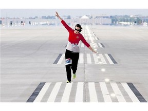 Louise Robinson imitates an airplane as she warms up prior to a public run for 1,400 joggers to celebrate the opening of Canada's longest runway at Calgary International Airport on Saturday. Reader suggests Calgarians shouldn't refer to the city as YYC outside of the airport setting.
