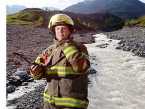 Mandie Crawford, flood communications co-ordinator and peace officer for the M.D. of Bighorn and volunteer firefighter, stands in the Exshaw Creek on May 27, 2014. The creek devastated the community when it turned into a raging river during the floods of 2013.