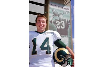 Marc Mueller, seen in 2009 as a quarterback of the University of Regina, stands in front of a large banner of his grandfather, legendary Saskatchewan Roughriders quarterback Ron Lancaster.