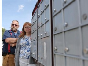 Mark Langlois, left and Stephanie Graves-Beckman are losing door to door mail service in Falconridge-Castleridge. (Leah Hennel/Calgary Herald)