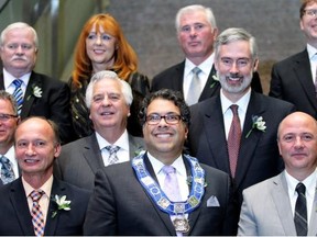 Mayor Naheed Nenshi is surrounded by other council members after their swearing-in ceremony in October 2013. A new report says city politicians’ workload is excessive.
