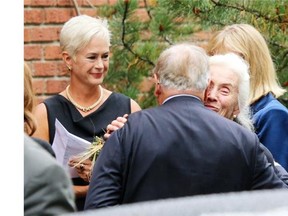 Ed McNally’s widow, Linda, is comforted by a mourner as daughter Shelagh McNally looks on following the funeral for the Big Rock Brewery founder on Thursday.