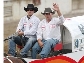 Nabors chuckwagon driver Rae Croteau Jr., right, and his codriver Calgary Flames Curtis Glencross wave to the crowd during Friday’s running of the GMC Rangeland Derby. If you take a picture of Croteau’s wagon and tweet it to #chucks4bucks, $1 will be donated to the Sheldon Kennedy Child Advocacy Centre.